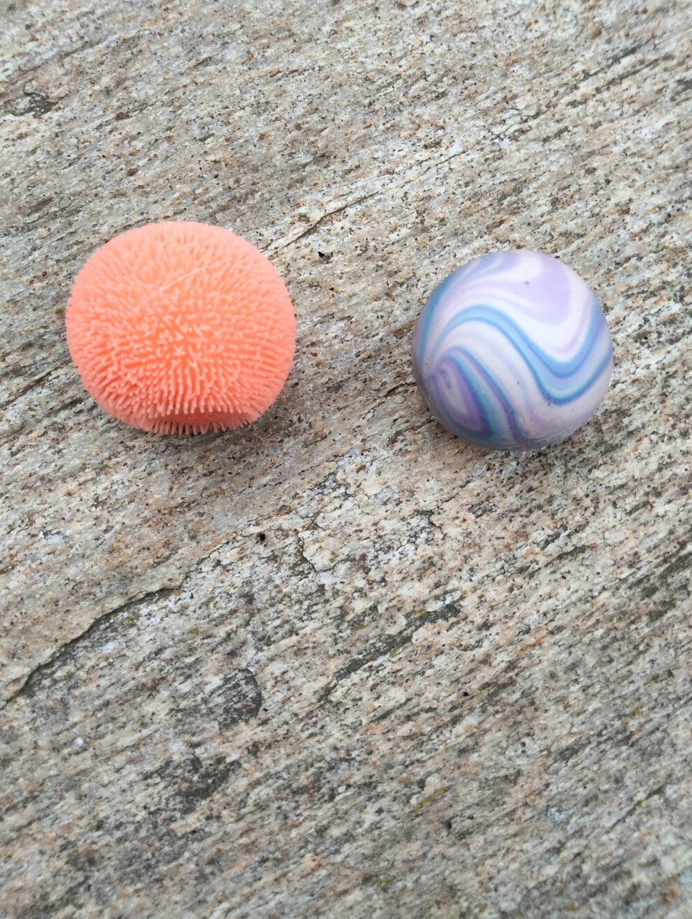 Two Needohs One Orange Fuzzball And One Pink And Blue Swirl
